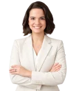 Una persona vestida con un traje de color crema, de pie con los brazos cruzados y sonriendo sobre un fondo blanco liso, que representa la profesionalidad y la confianza del bufete de abogados Godoy.